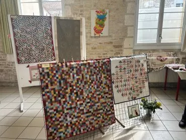 Exposition de tissus colorés réalisés en patchwork