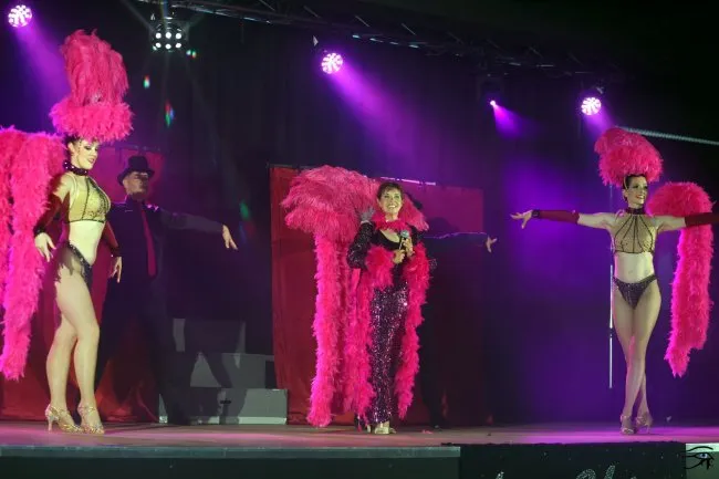 Miss Flo et sa troupe sur scène habillées de plumes roses