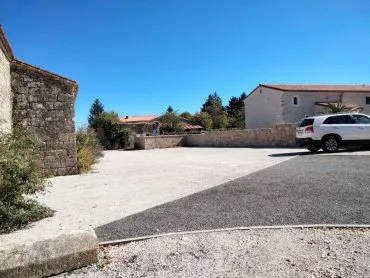 Parking presque vide avec une voiture blanche, ciel bleu