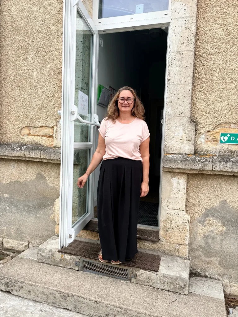 nouvelle directrice dans encadrement de porte de l'école, souriante